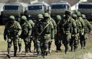 Armed men, believed to be Russians, march at their camp near the Ukrainian military base in Perevalnoye
