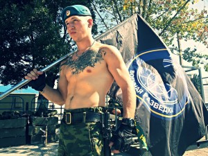 Фотогарфия Раменского с флагом военной разведки РФ и нео-нацисткой татуировкой